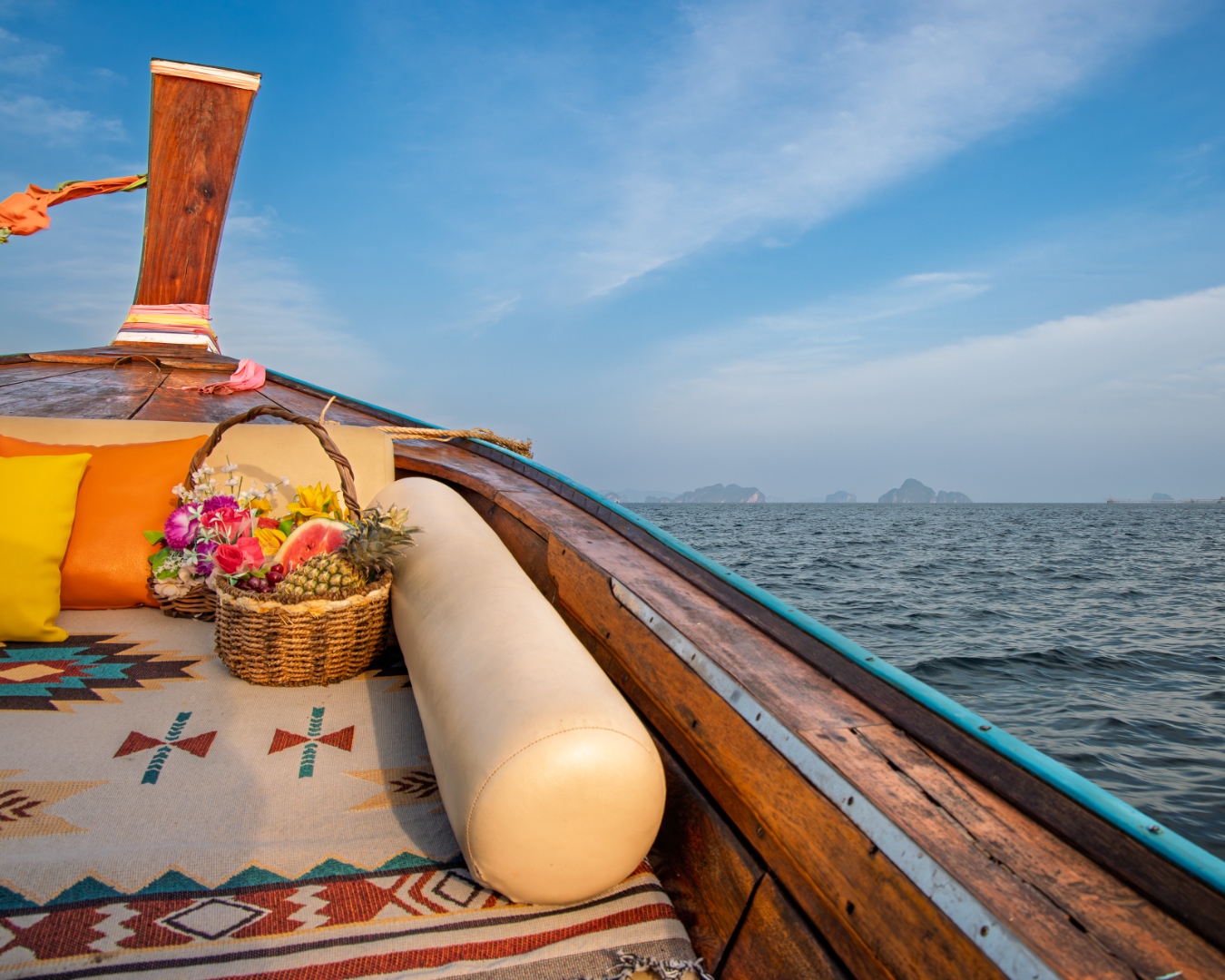 Longtail boat bow with fruit basket and cushions on open water, Andaman Sea, Thailand — travel photography