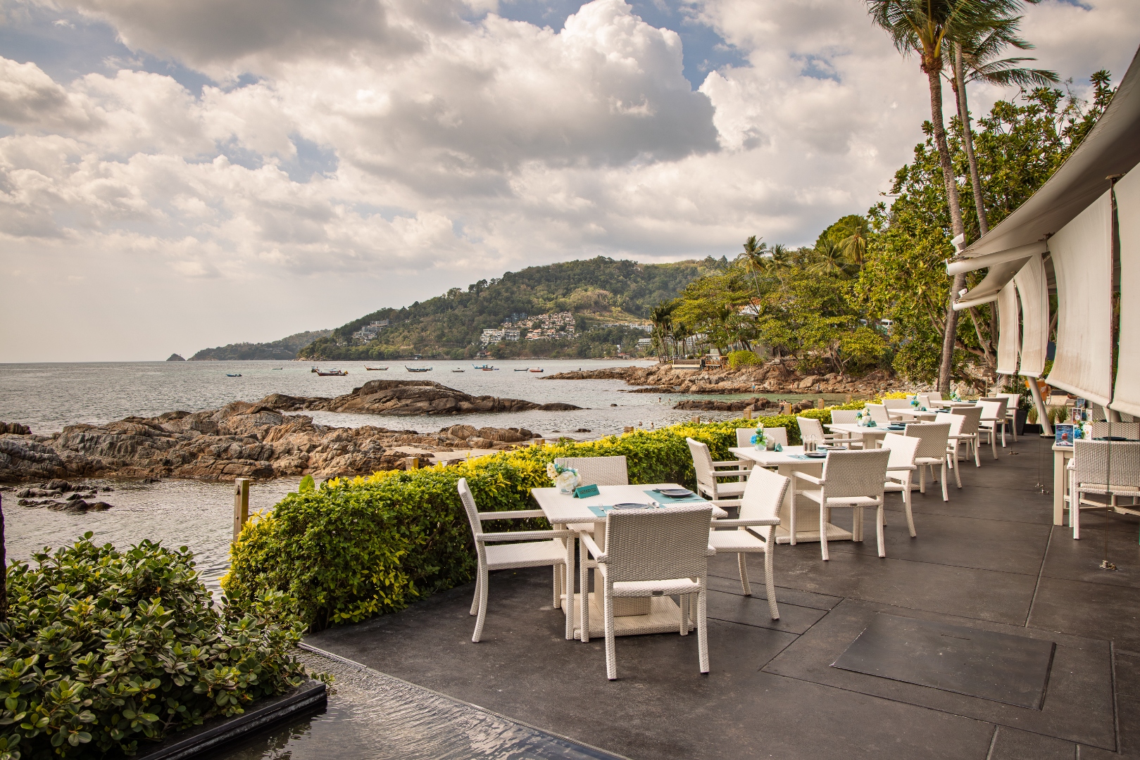 Oceanfront restaurant terrace overlooking a rocky cove — hospitality photography by Samuel John Ford